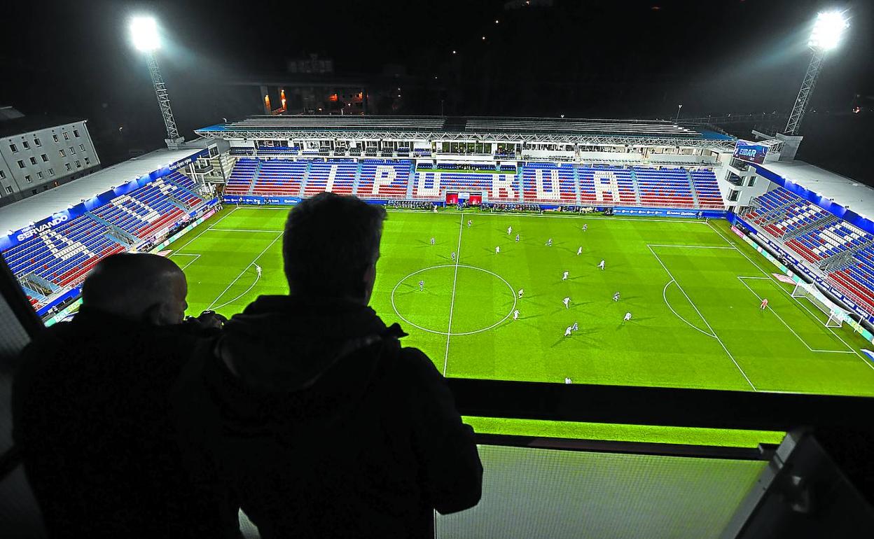 Dos vecinos observan desde casa el Eibar-Real, último partido de Liga hasta ahora. Se desconoce cuándo volverá a rodar el balón y si será con público.