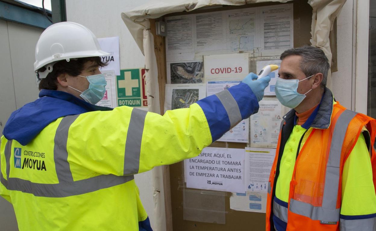 Toma de temperatura, ayer, a un trabajador antes de iniciar su jornada en una obra de construcción. 
