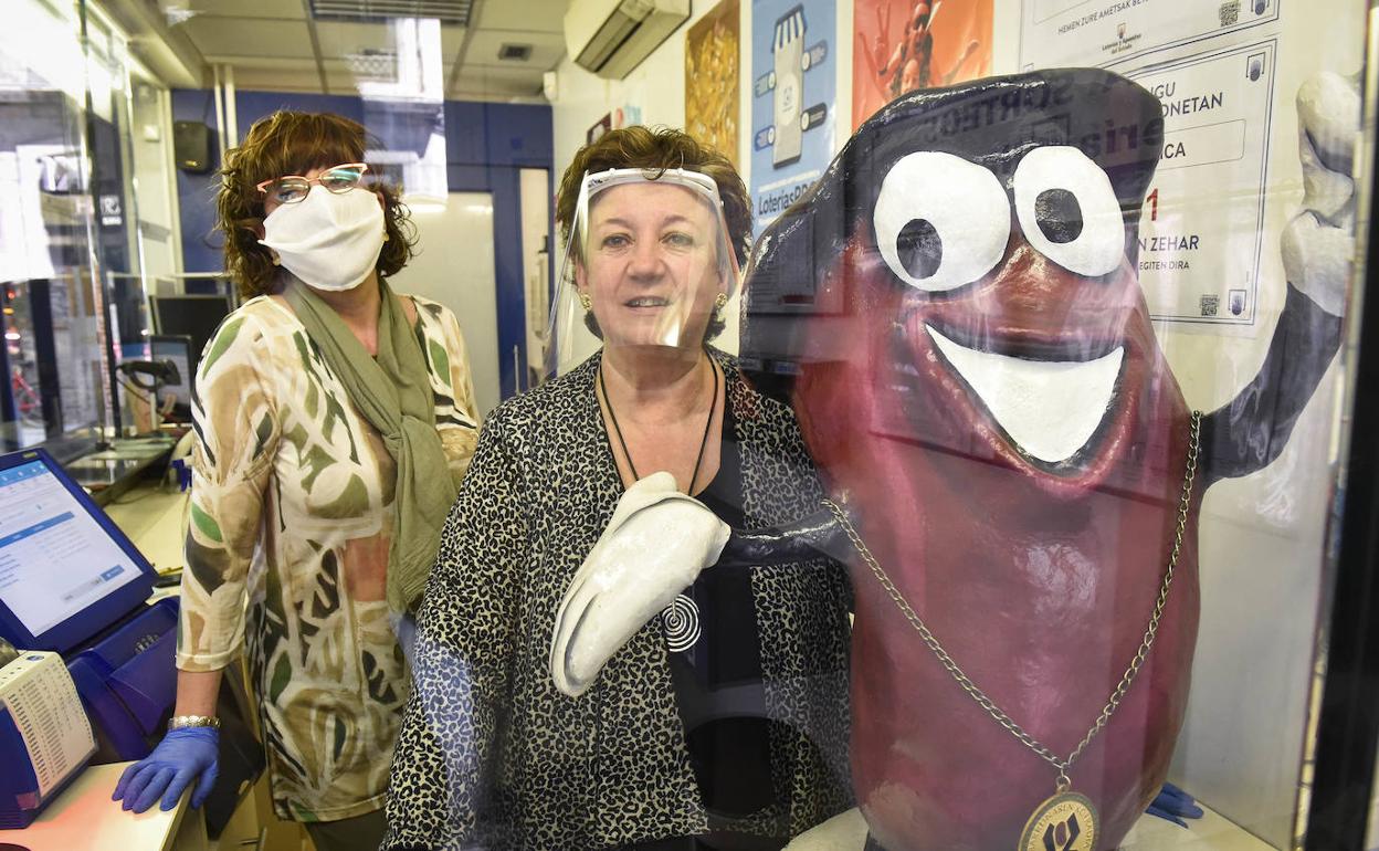 Maite y María Jesús, con la mascota que desde hace quince años da nombre a su administración: la Alubia Mágica. 