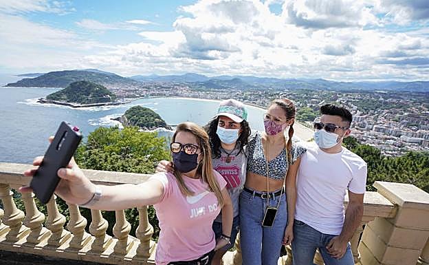 Los vizcaínos Goizane, Ane, Nuria y Ander, de fin de semana en San Sebastián, posan para un selfi con la bahía de La Concha al fondo.