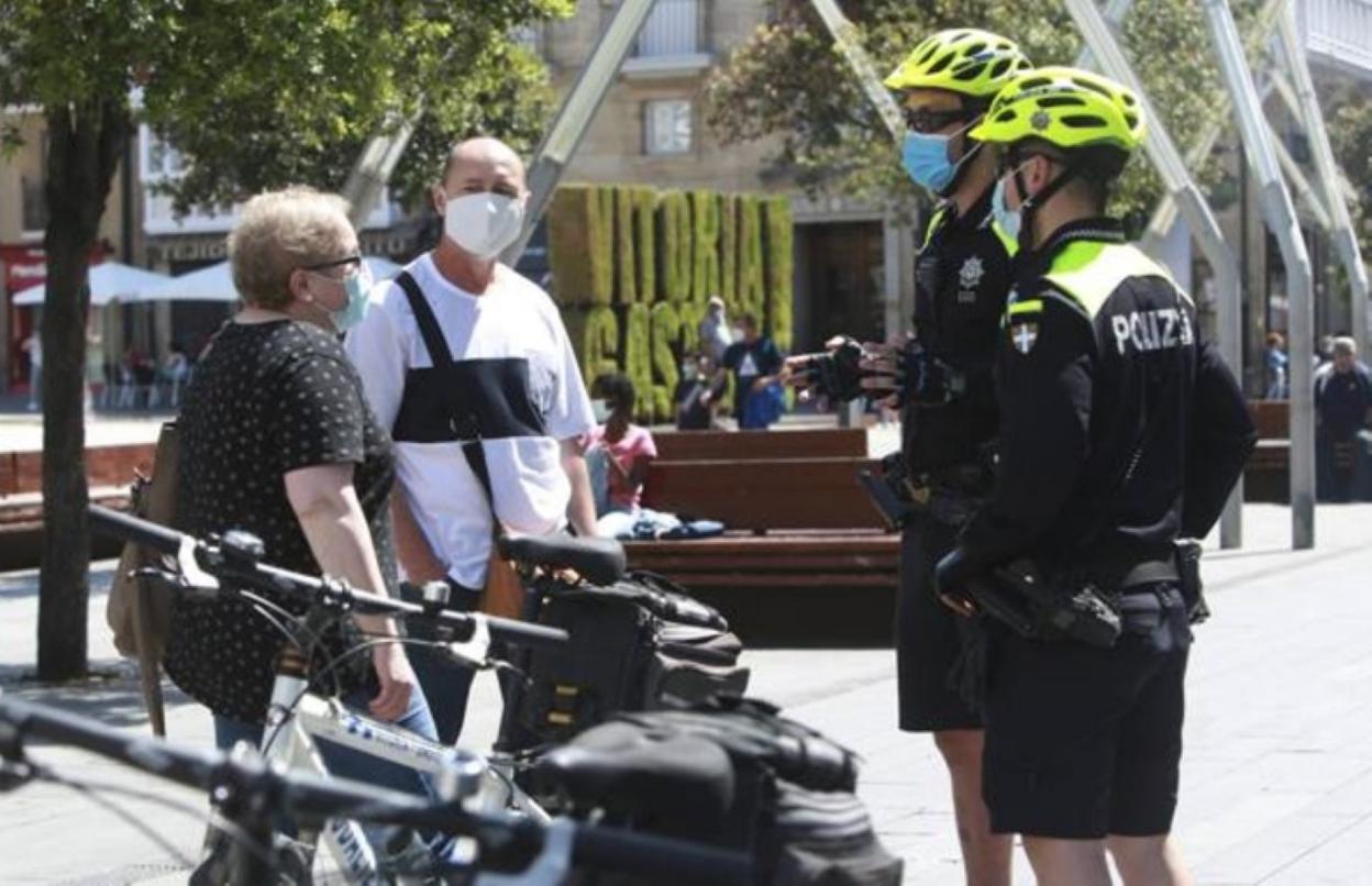 Una patrulla de bicipolis atiende a un par de ciudadanos. 