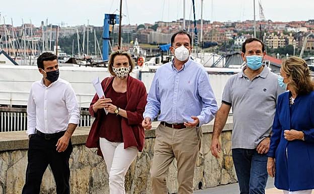 Carlos Iturgaiz, tras reunirse con miembros de la logística electoral del PP, disfrutó de un paseo con compañeros en el muelle de Las Arenas.