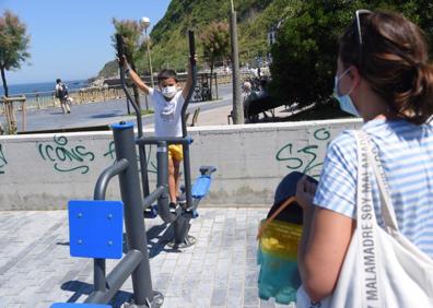 Imagen secundaria 1 - Josune Areso, sale de la playa de la Zurriola, con sus dos hijas de 10 y 6 años..Jaione Rodríguez no tiene reparo en que su hijo vaya a las colonias, «siempre va con mascarilla». Aitor Idígoras podrá seguir llevando a Juka a las colonias. Al ser privada no tienen la obligación de cerrar.