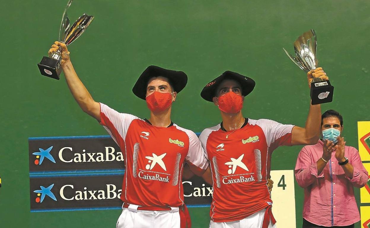 Los campeones Agirre y Eskiroz, con sus txapelas, sus trofeos y sus mascarillas.