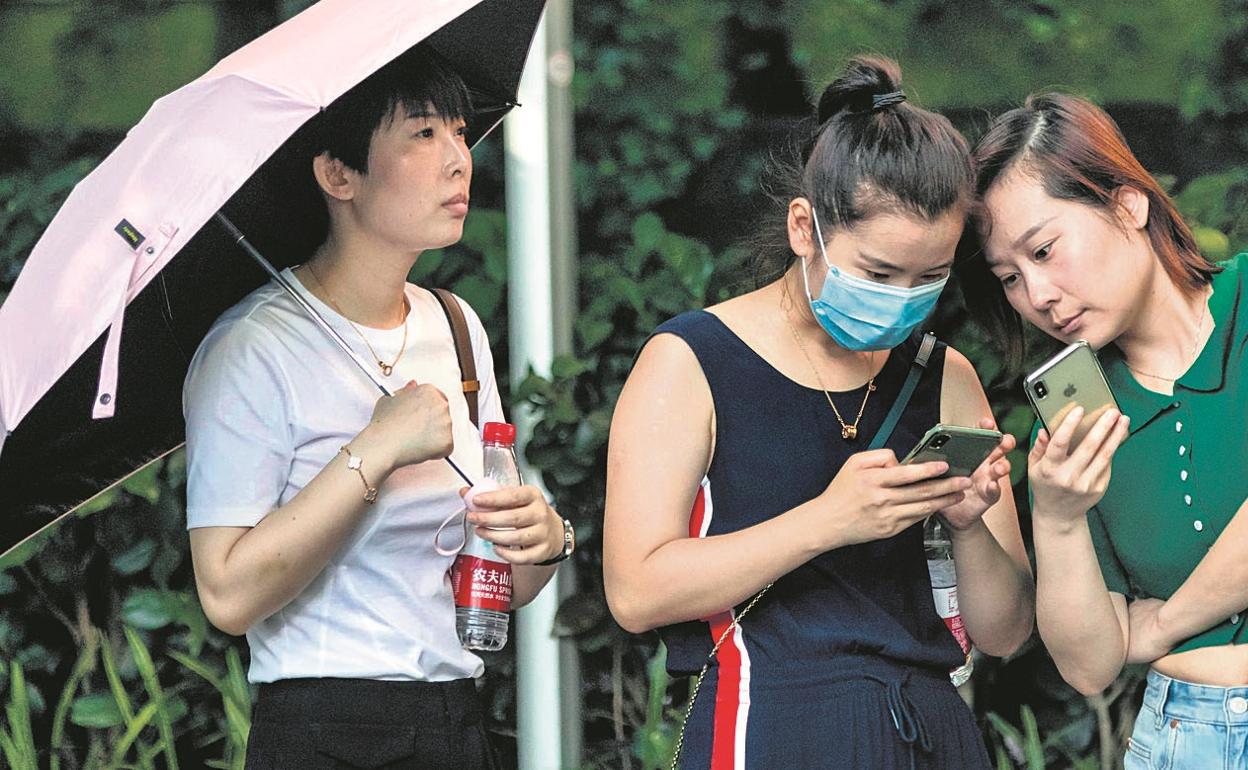 óvenes chinas utilizan la aplicación TikTok en Shanghái.