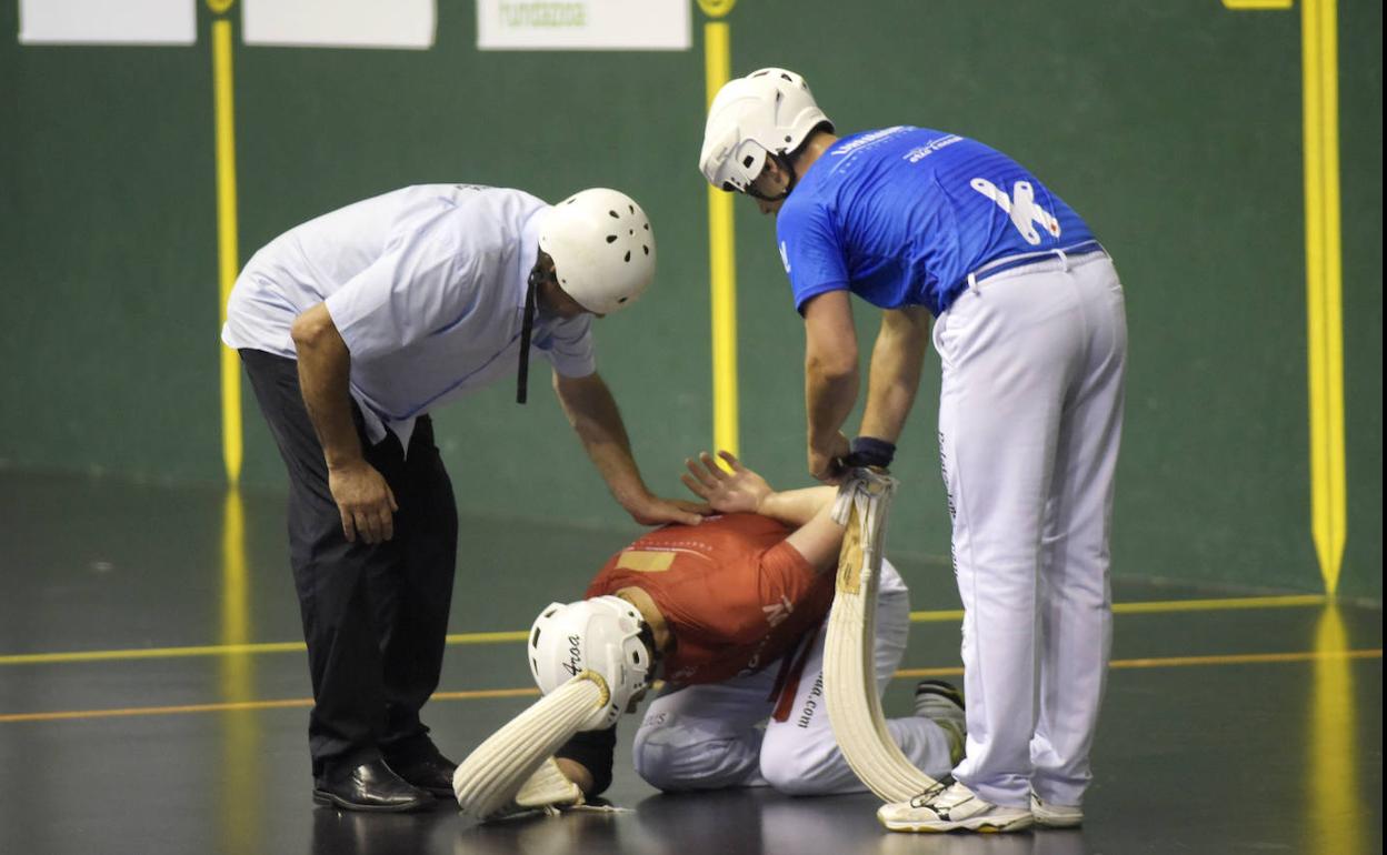 Juanenea, atendido por el juez Eugenio Aranburu, y Larrañaga tras el pelotazo en la espalda. 