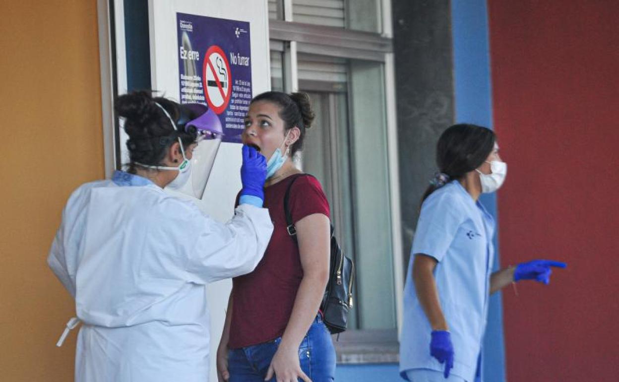 Una sanitaria realiza una prueba PCR a una mujer que estuvo en alguna de las discotecas de Donostia entre el 14 y el 16 de agosto.