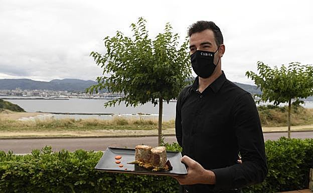 Un camarero de Cubita sostiene un plato en la terraza orientada hacia El Abra.