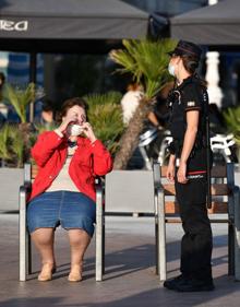 Imagen secundaria 2 - La ertzaina invita a una mujer a colocarse adecuadamente la mascarilla, por encima de la nariz. 