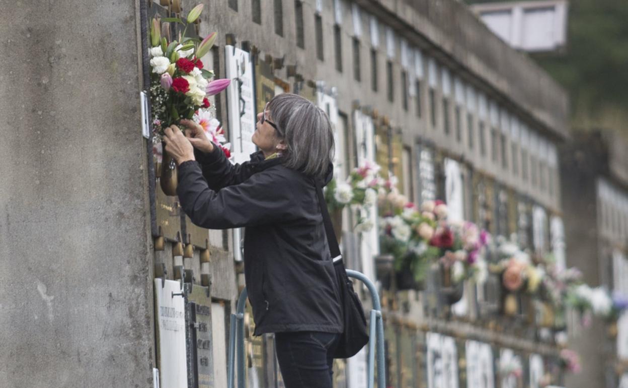 Una mujer coloca flores frescas, ayer en un nicho de Blaia. 