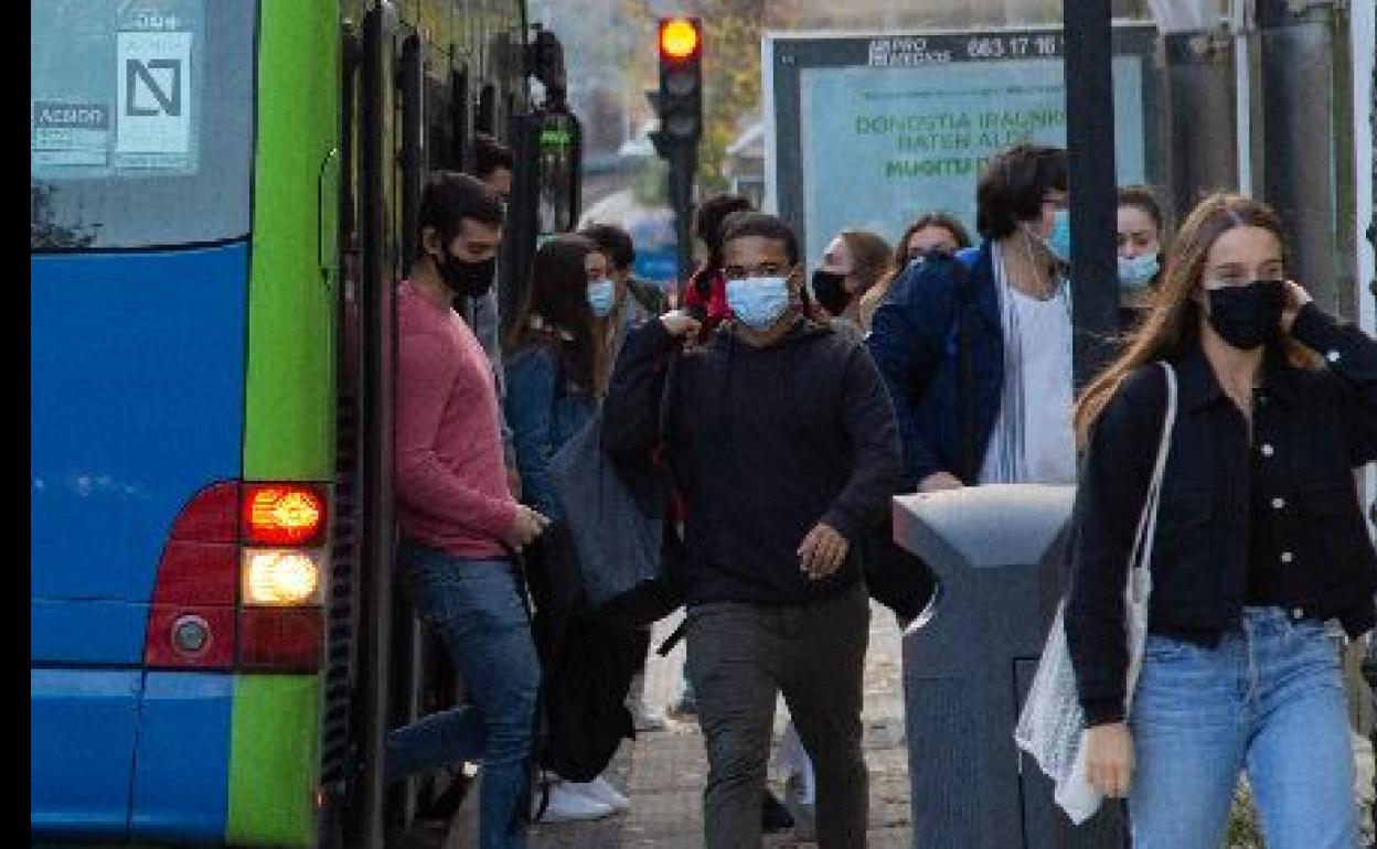 Varios jóvenes descienden de un autobús de Dbus junto al campus universitario de Ibaeta, a primera hora.
