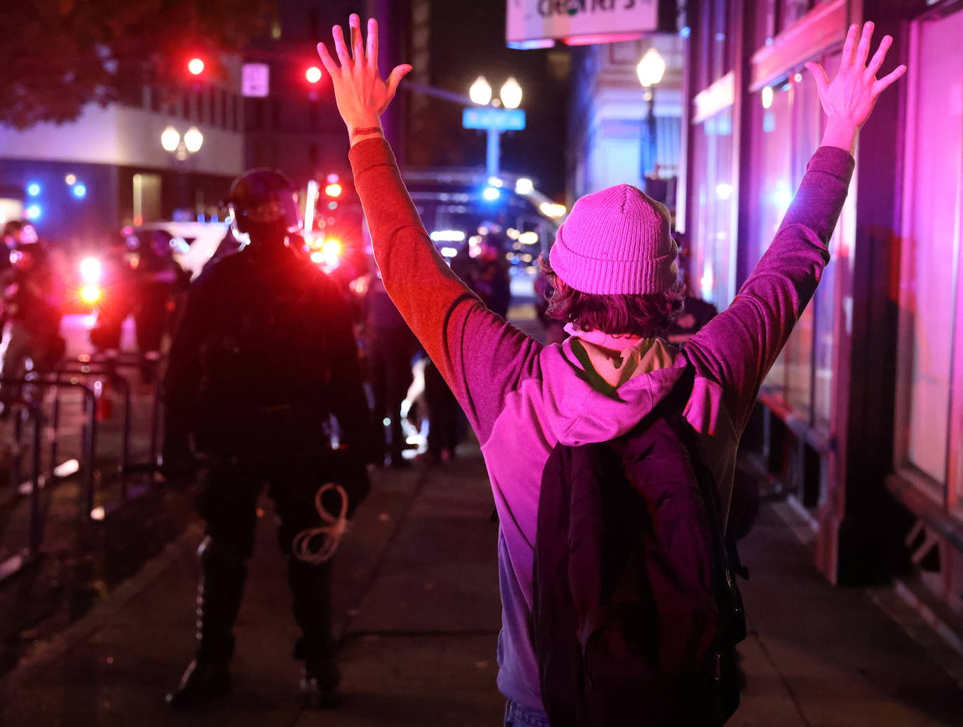 Un manifestante levanta las manos frente a la policía durante una protesta el día después del día de las elecciones en Portland, Oregon, EE. UU.