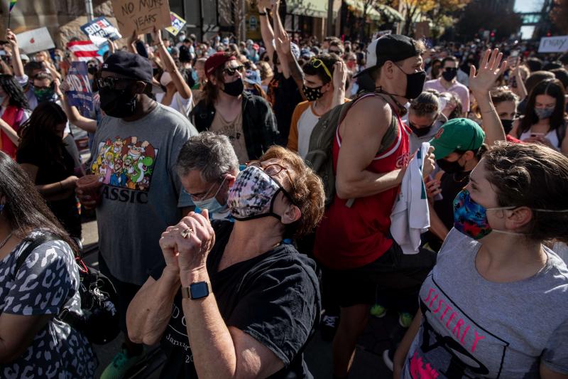 Una mujer agradece mirando al cielo el triunfo electoral de Joe Biden.