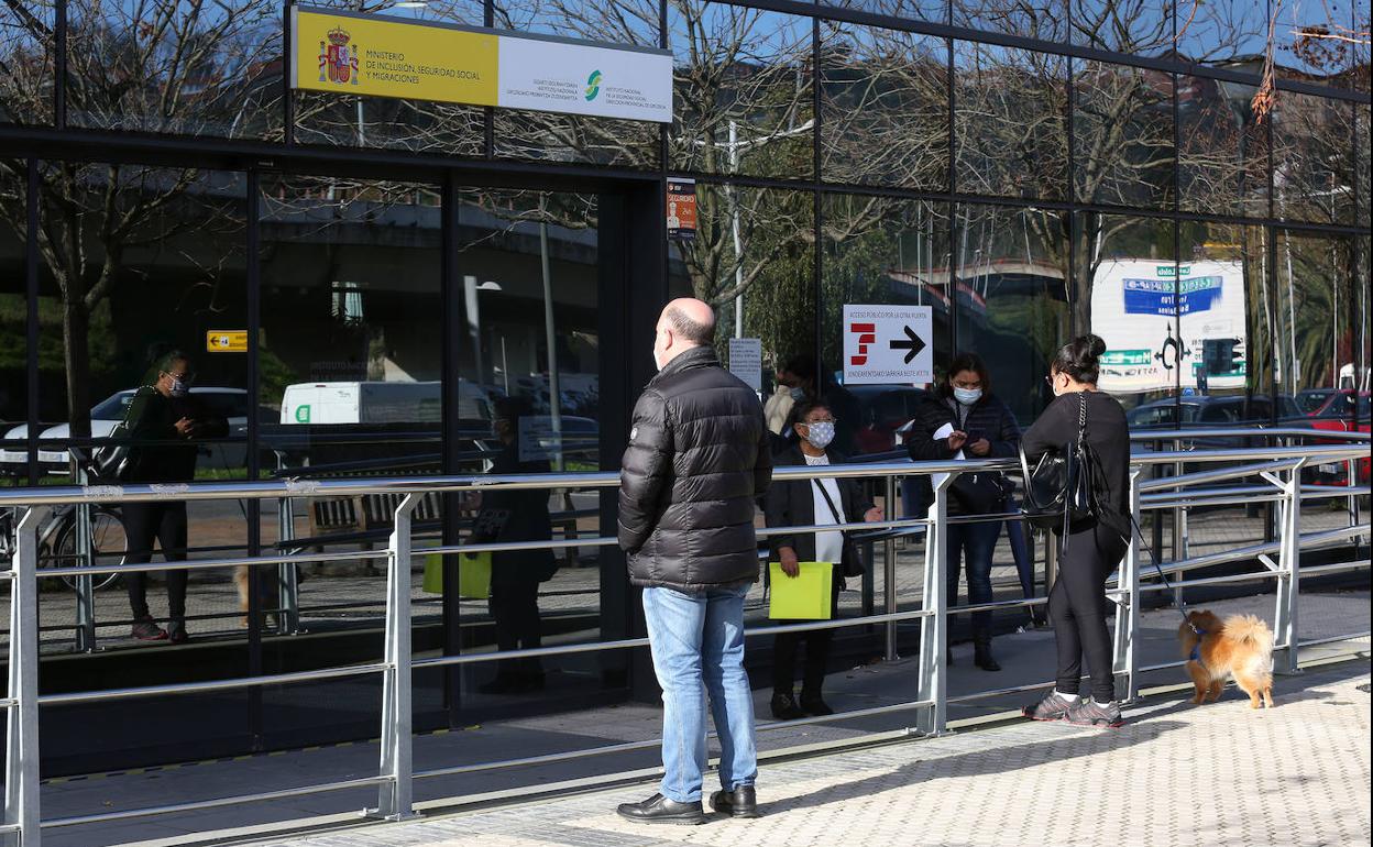 Personas esperan a las puertas de la Seguridad Social, en el edificio situado en Riberas de Loiola, en Donostia.