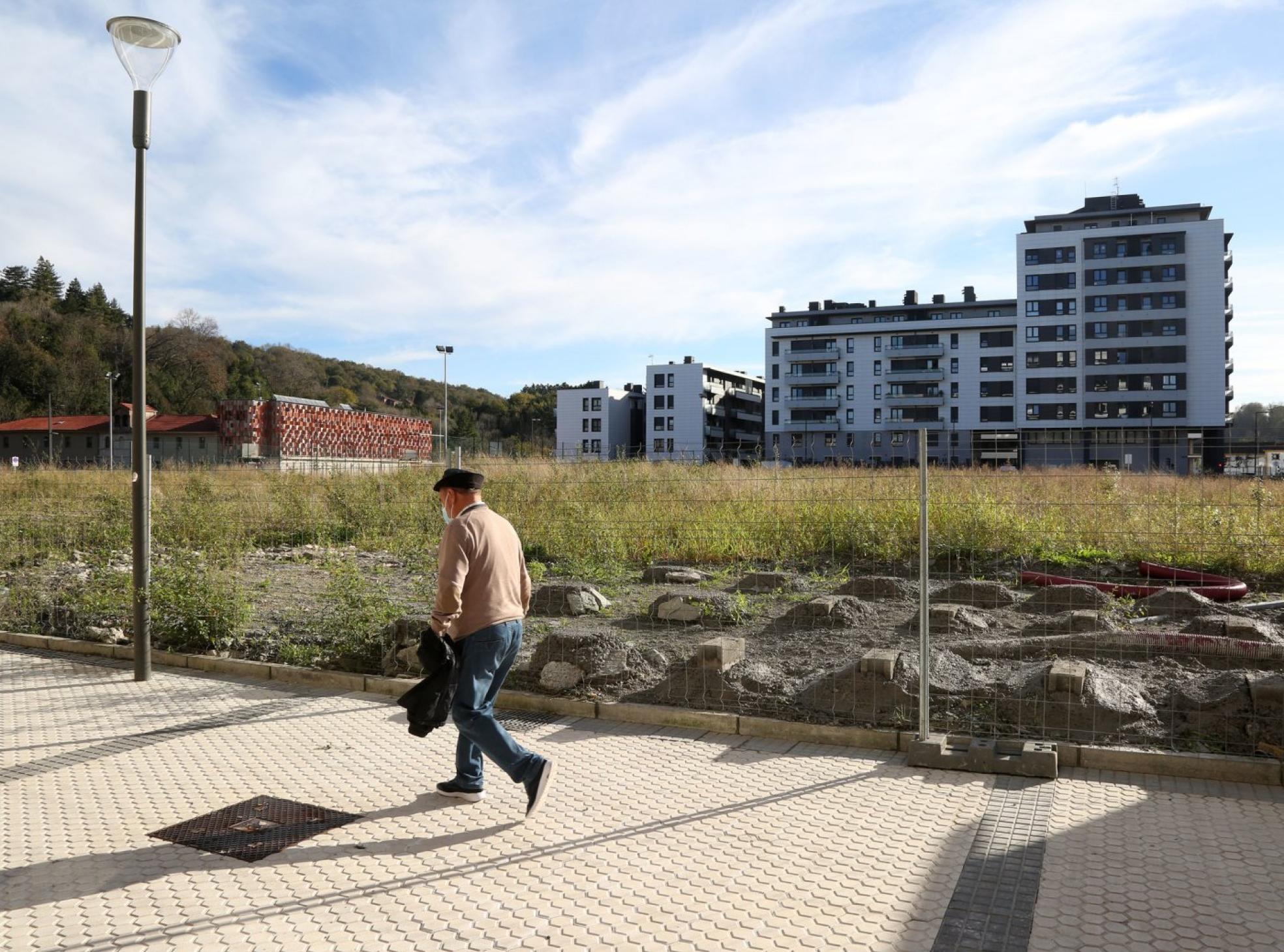 Un hombre camina ante el solar destinado aequipamiento cultural y deportivo. 