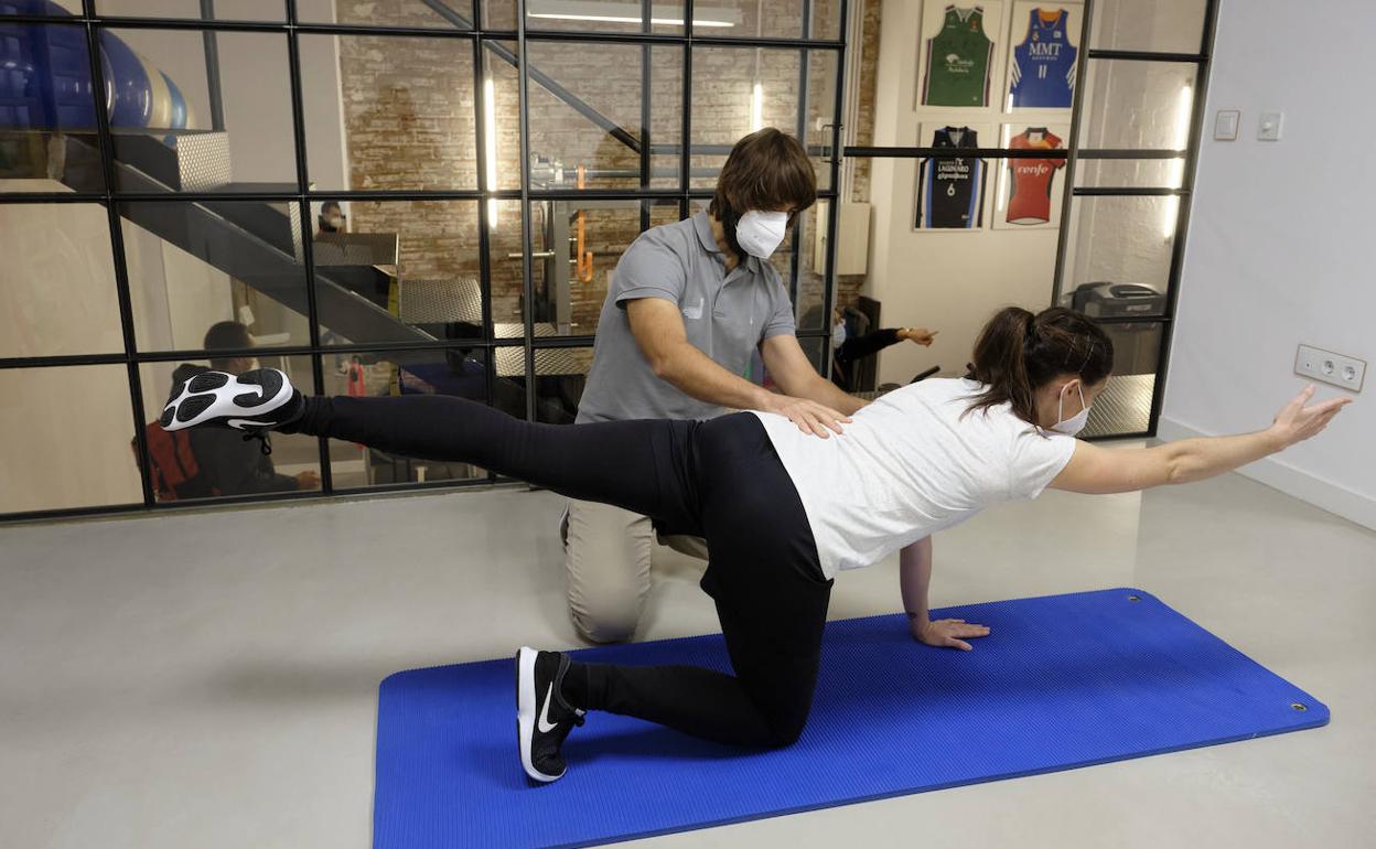 El fisioterapeuta donostiarra Igor Sancho ayuda a hacer ejercicios a una clienta.