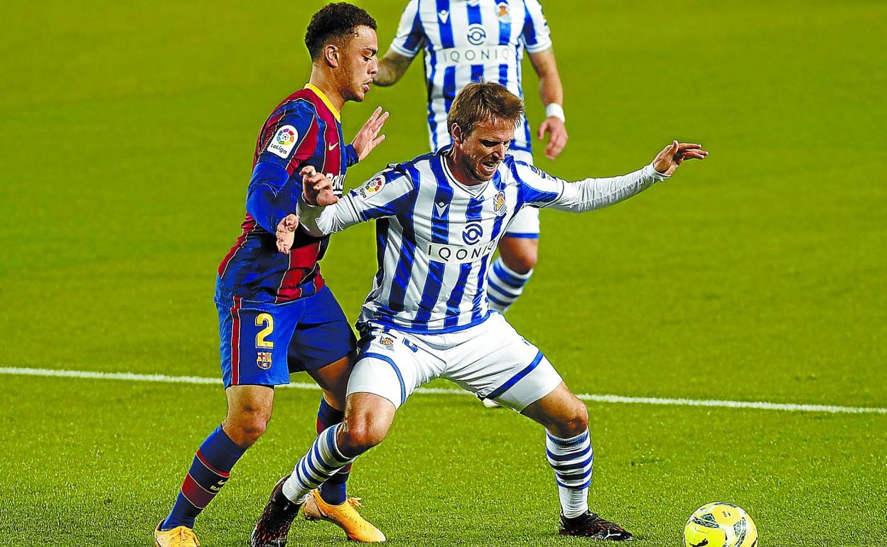 Monreal trata de proteger el balón anteel acoso del barcelonista Sergiño Dest,anoche en el Camp Nou. 