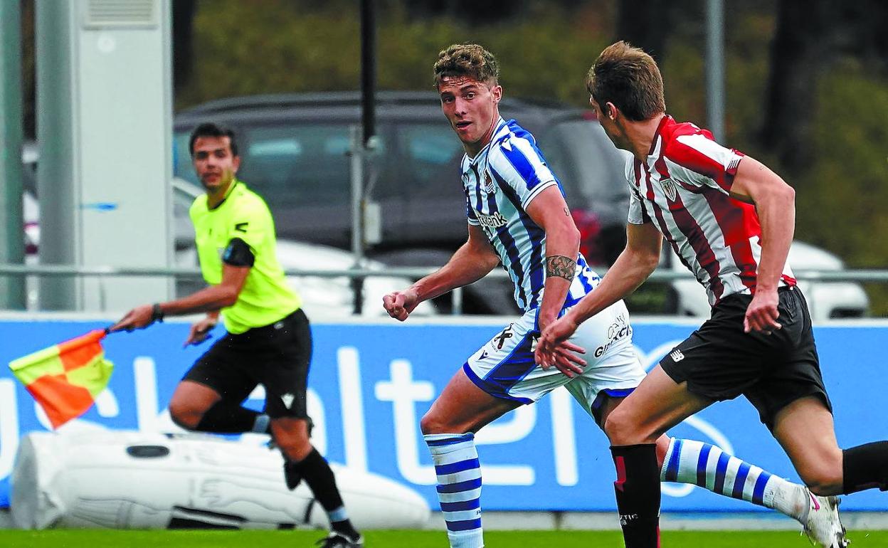 Jorge Aguirre conduce el balón ante la oposición de un jugador bilbaíno en el derbi disputado en Zubieta a puerta cerrada. 