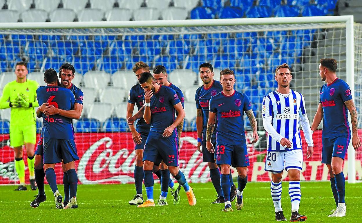 Los jugadores del Atlético celebran su primer gol, ante la desolación de Remiro y Monreal.