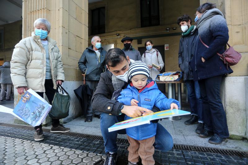 Makel mira junto a su aita Kamel, su ama Itsaso, sus aitonas y tíos el libro que Olentzero le dejó en la Plaza de Gipuzkoa de Donostia. 