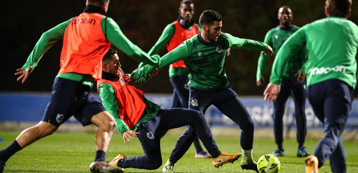 Merino sortea la entrada de Roberto López en el entrenamiento de ayer de Zubieta. 