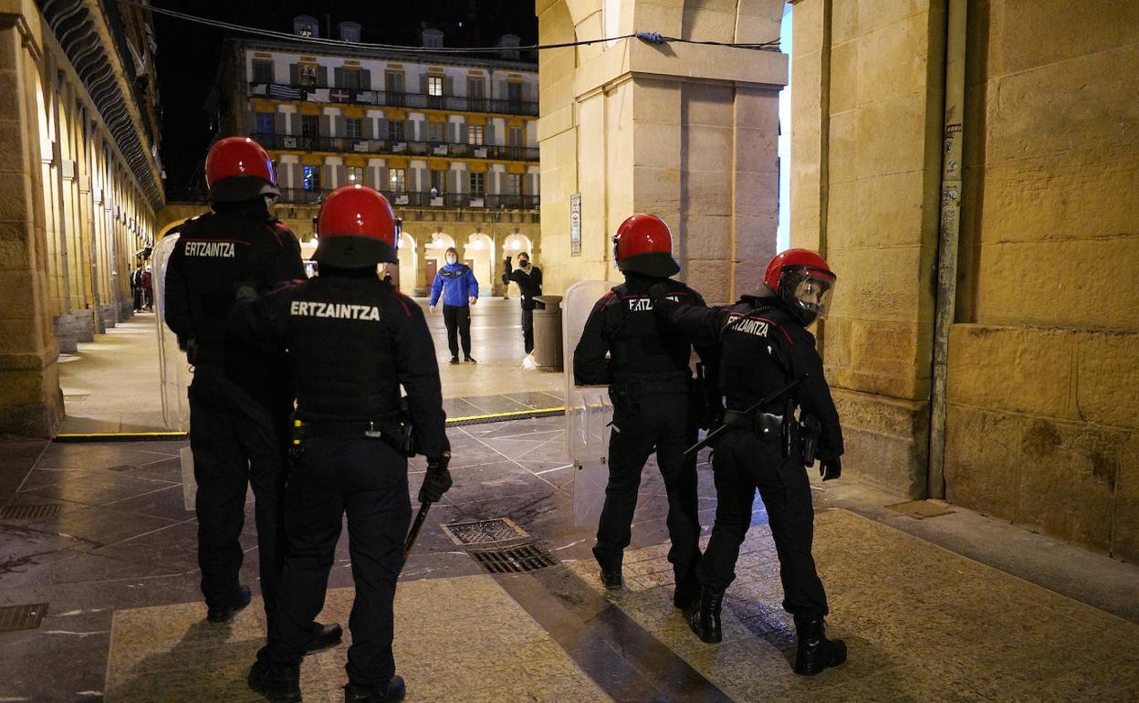 Dos jóvenes se enfrentan a agentes de la Ertzaintza en la plaza de la Constitución.