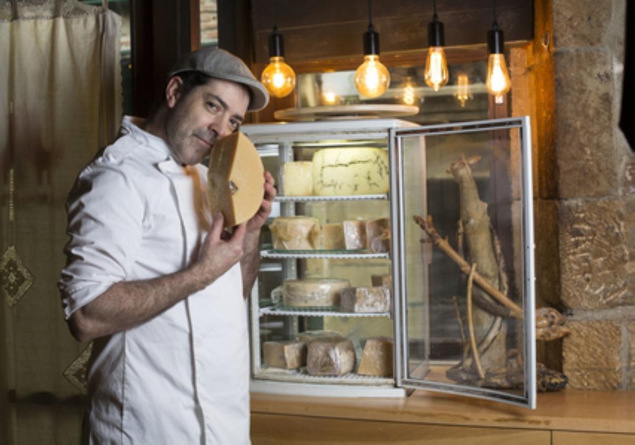 Gorka Irisarri, propietario de Danontzat Gastroteka, en el exterior de su restaurante con un queso. 