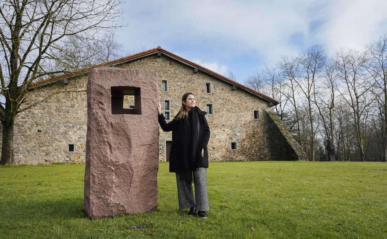 La directora de Chillida-Leku, Mireia Massagué, con la escultura 'Lo profundo es el aire-Estela XII'. 