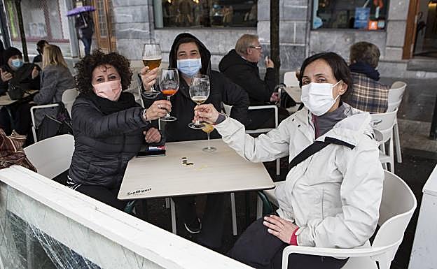 Imagen principal - Lorena, Sonia y Jimena disfrutaban ayer juntas tomando algo después de haber terminado su paseo. La próxima, dicen, será en casa; Aitor y sus amigos lamentan que solo tenga que cerrar la hostelería y Antonio, del bar Gaztelumendi, no sabe cuánto podrán aguantar esta situación.