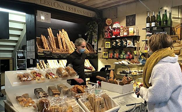 Aitor Lekuona atiende a una clienta en su panadería. 