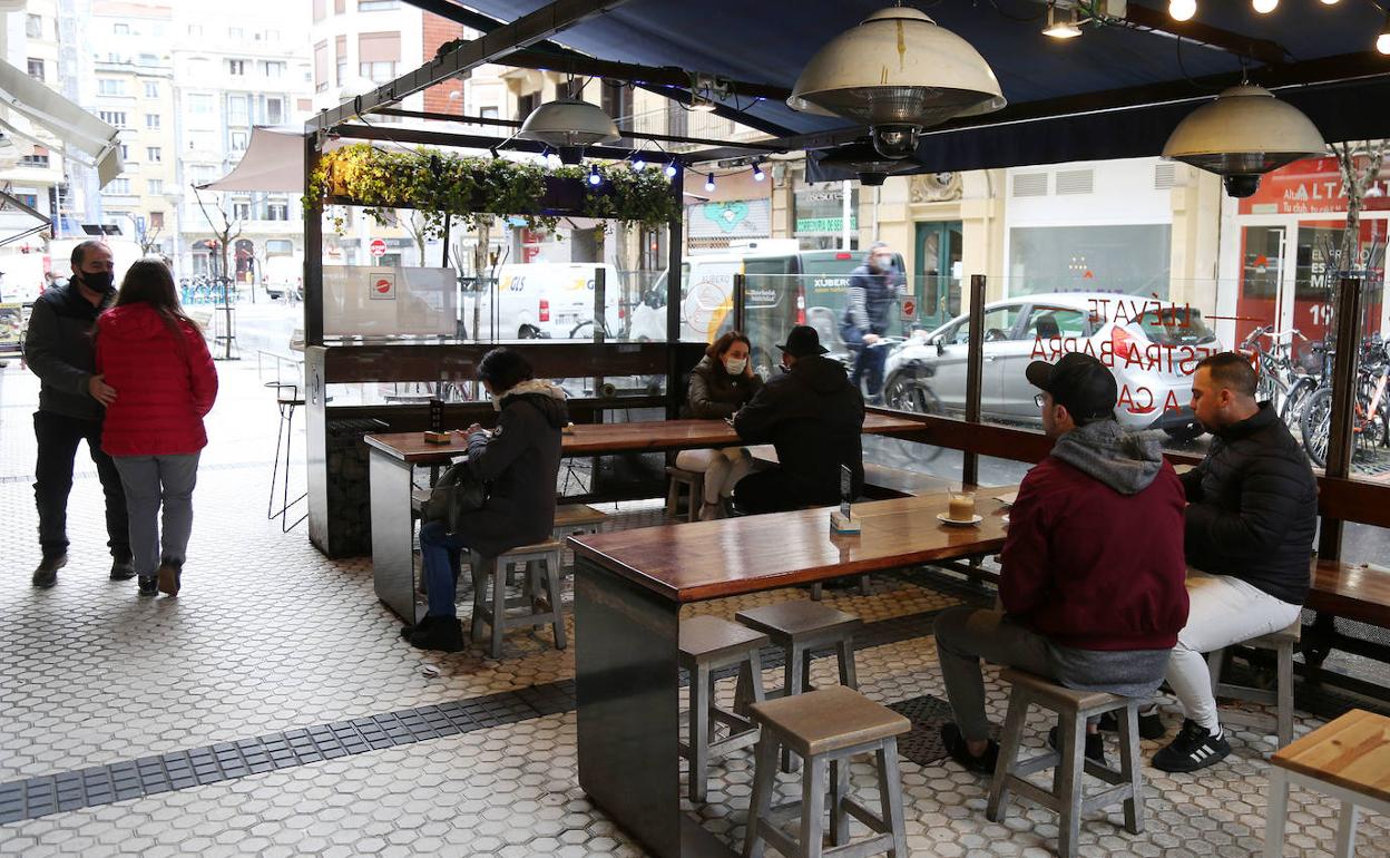 Varias personas toman una consumición en la terraza de la Bodega Donostiarra.
