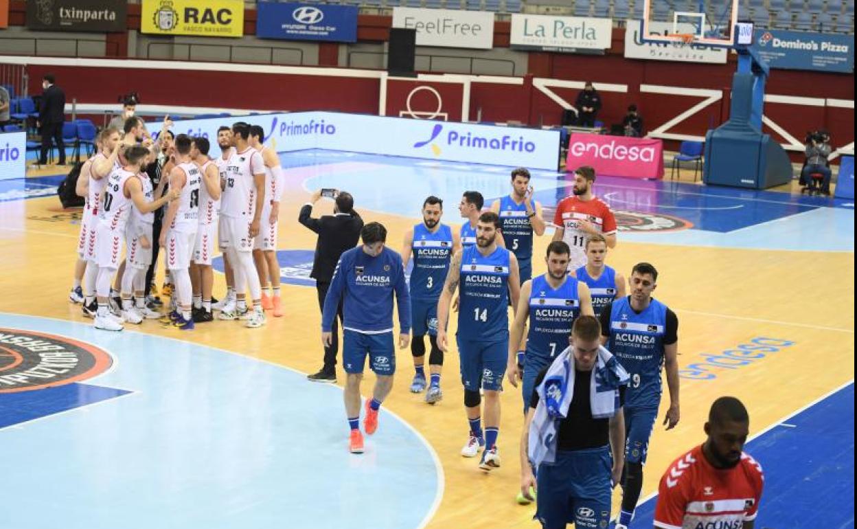 Los jugadores del Acunsa GBC se retiran cabizbajos a vestuarios a la conclusión del partido mientras a la espalda Bilbao Basket celebra la victoria ayer en Illunbe.