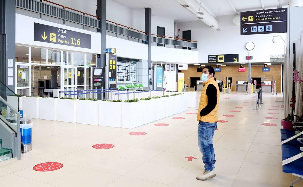 Un viajero observa el panel de información del aeropuerto de Hondarribia.