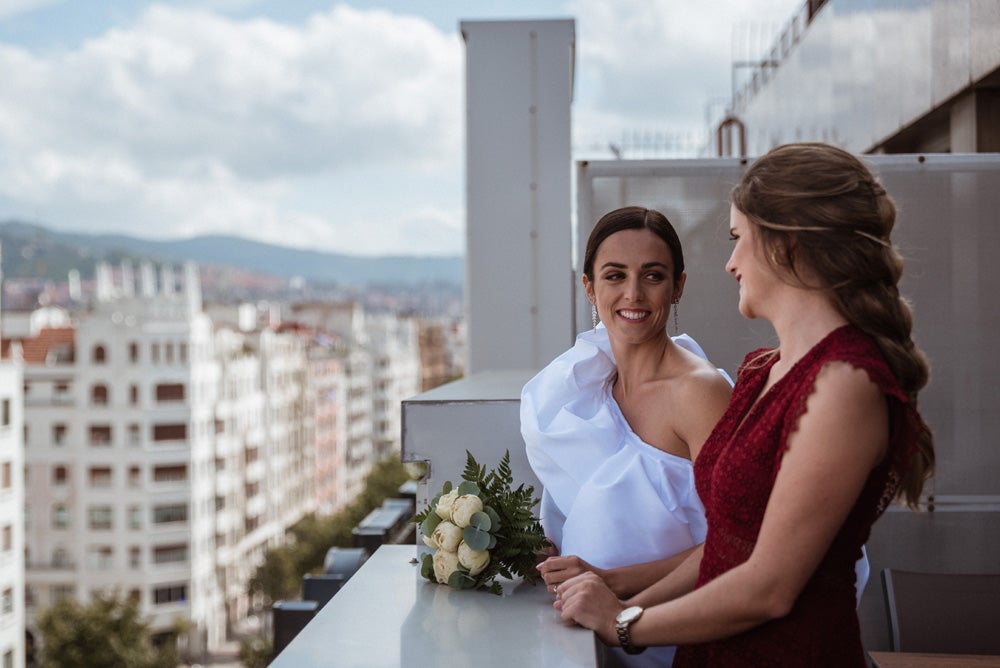 María y Jorge se casaron en Gorliz en una ceremonia íntima adaptada a las circunstancias. De largura 'mini' por encima de la rodilla, con corte asímetrico, volumen en la parte superior y lazadas laterales, la protagonista se ha convertido en una de las novias más impresionantes de las últimas semanas. El diseño lo ha firmado Fabio Encinar, uno de los diseñadores con sede en Madrid más de moda. En cuanto al peinado, otro de los elementos más destacados del estilismo, ha optado por un acertado moño bajo de bailarina súper pulido y tirante, con horquillas de Oui Novias