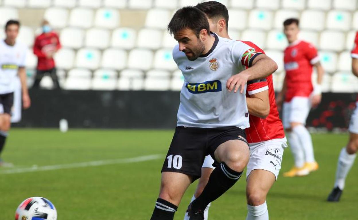 Galán, capitán unionista, protege un balón ante un defensa rival.