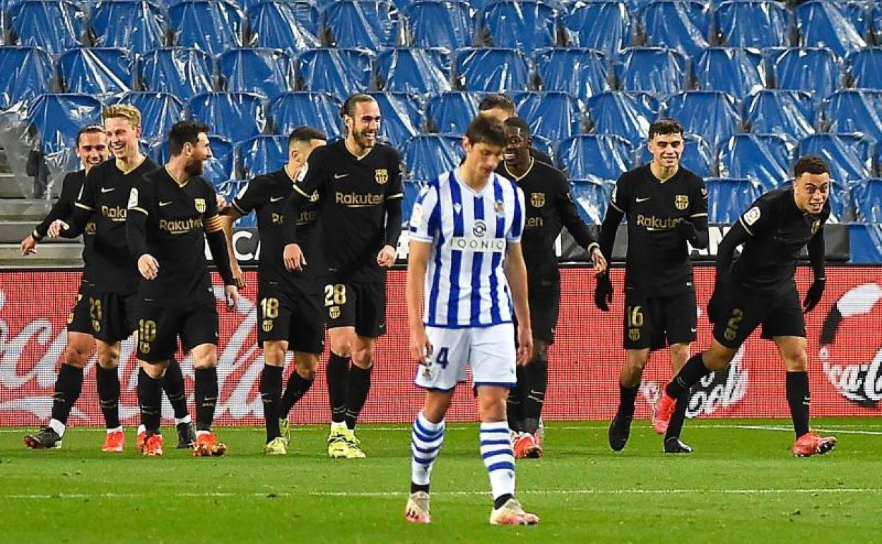 Los jugadores del Barcelona celebran uno de los seis goles que marcaron a la Real en Anoeta, mientras Le Normand se muestra cabizbajo.