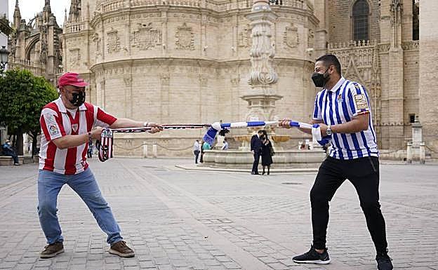 De la Fuente y Carrasco improvisan una competición de soka-tira con las bufandas de sus equipos, junto a La Giralda.