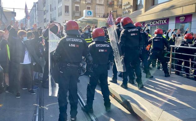 Imagen principal - Algunos momentos de tensión de la protesta vivida esta mañana de viernes frente al Parlamento vasco. 