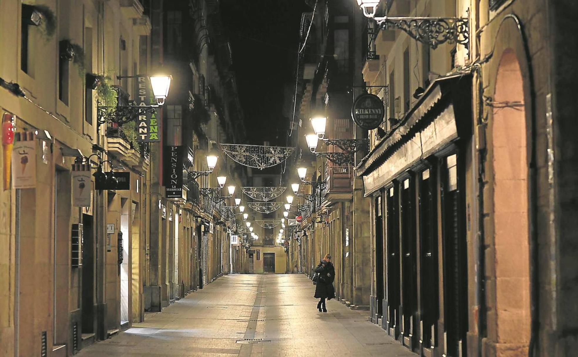 Una mujer camina por una calle de la Parte Vieja. 