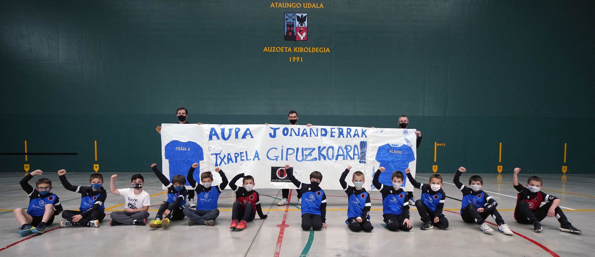 Niños de la escuela de pelota de Ataun junto a sus monitores muestran en el frontón Auzoeta su pancarta de apoyo a Peña II y Albisu