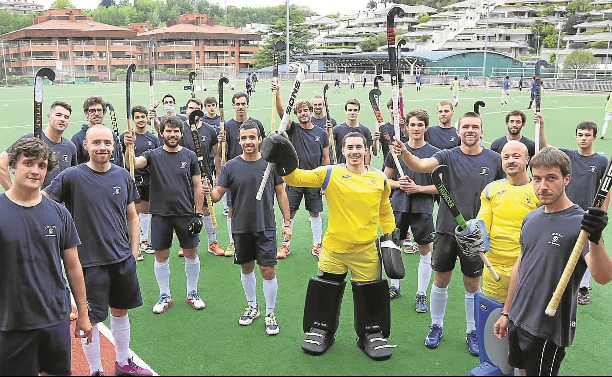 La plantilla del Atlético levanta sus sticks antes de entrenar en el campo de Aiete.