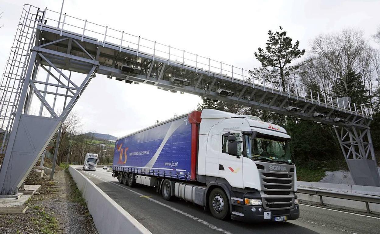 Un camión pasa bajo el arco de peaje.