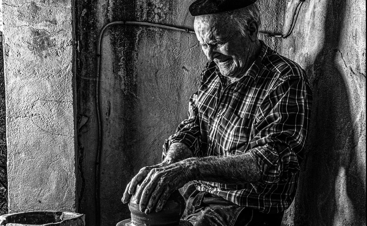 Juanjo Goyeneche trabaja la arcilla en el torno que se recuperó para hacer el libro. 