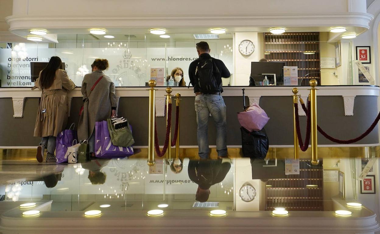 Turistas en la recepción de un hotel. 