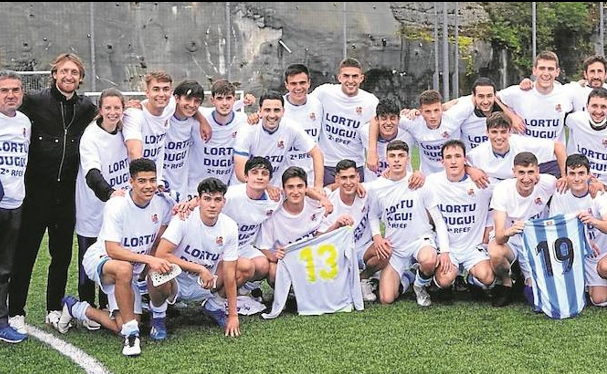 Los jugadores y técnicos de la Real C, respaldados por el presidente Aperribay, el día que concretaron el ascenso a Segunda RFEF. 