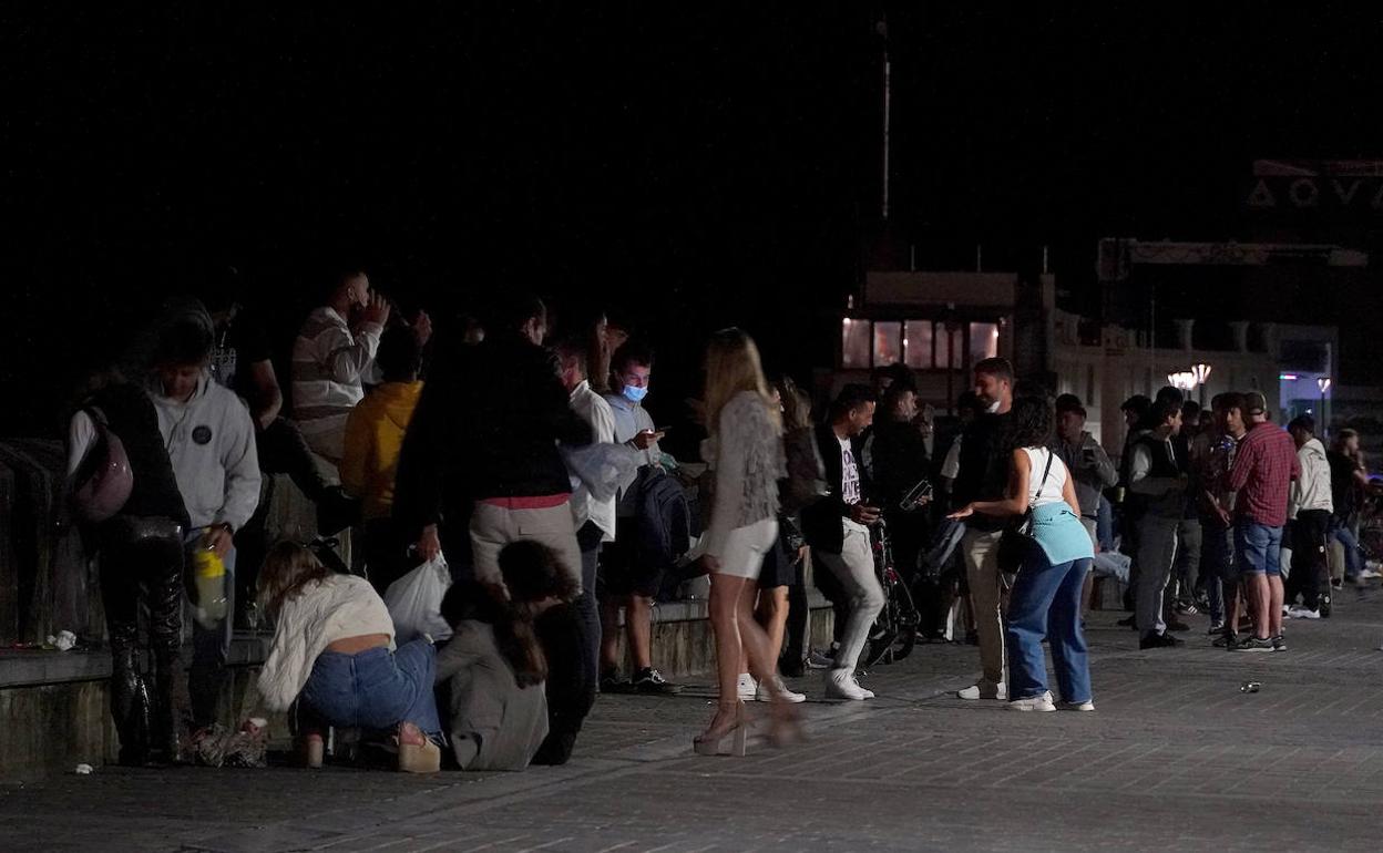 Un nutrido grupo de jóvenes bebe en la vía públiza, en la zona del Muelle donostiarra. 