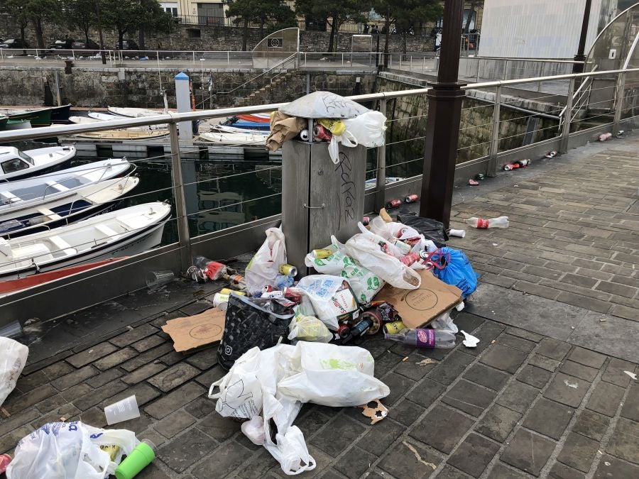 El puerto donostiarra ha amanecido cubierto de restos de plásticos y cristales después de una noche de botellón