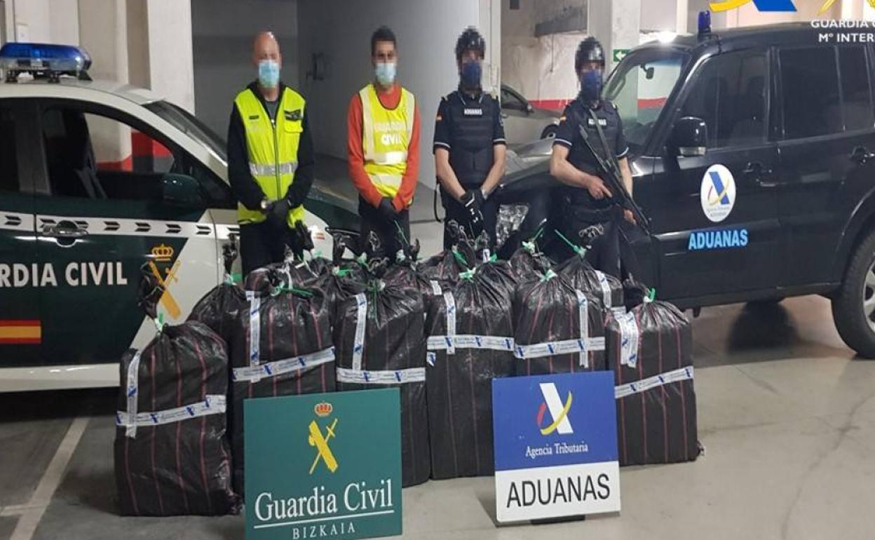 Miembros del servicio de Aduanas del Puerto de Bilbao y agentes de la Guardia Civil, con la droga incautada, 