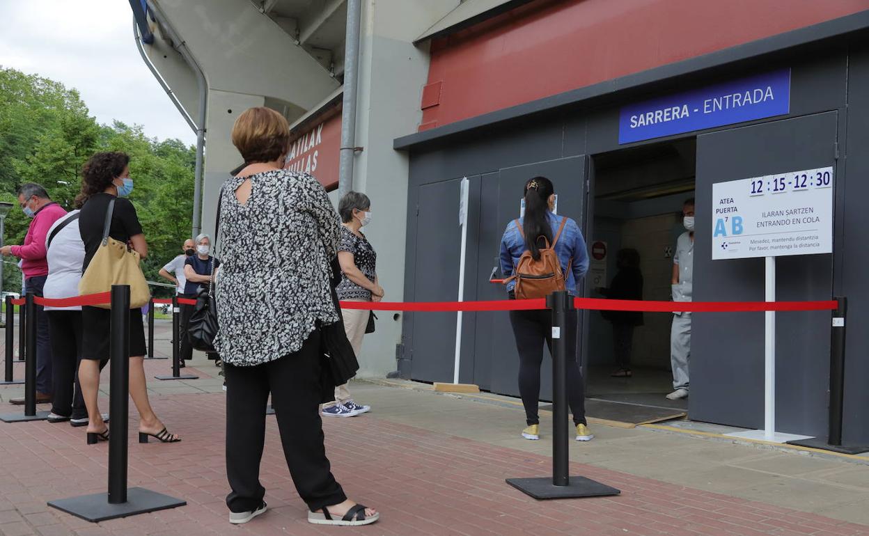 Un grupo de personas hace cola para vacunarse en Illunbe. 