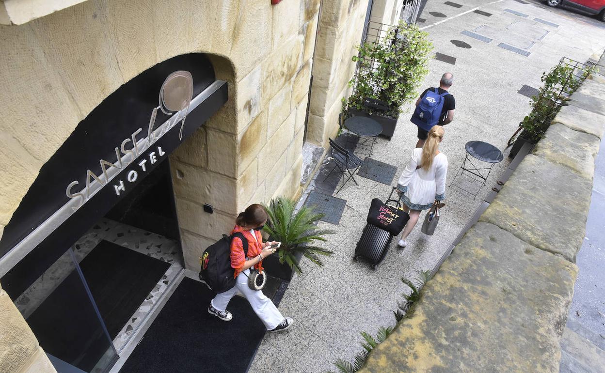 Varios turistas salen de un hotel donostiarra. 